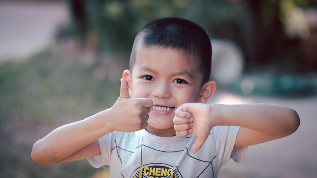 Retrato de um lindo garoto asiático sorrindo alegremente correndo no espaço da cópia do playground Garoto feliz se divertindo ao ar livre, um garoto asiático ativo passando as férias de verão com prazer em um campo