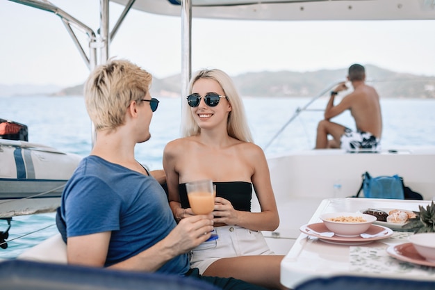 Retrato de um lindo lindo casal homem e mulher, bebendo em um café local em um iate.