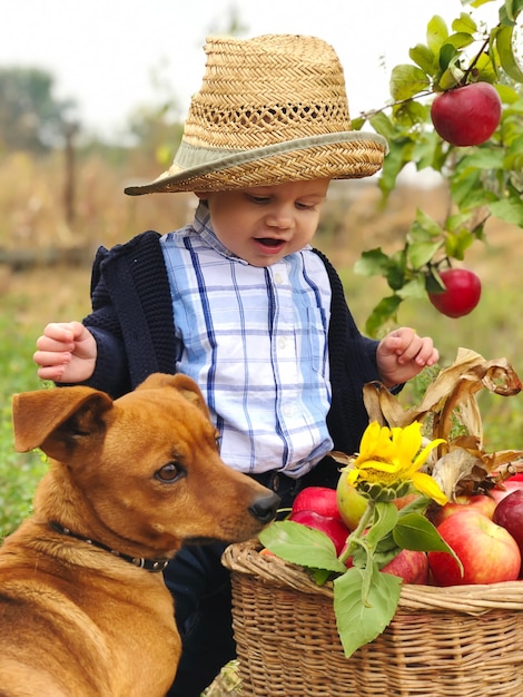 Retrato de um lindo menino comendo maçã no gramado