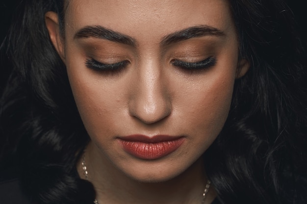 Foto retrato de um lindo rosto feminino com maquiagem extrema de cílios longos