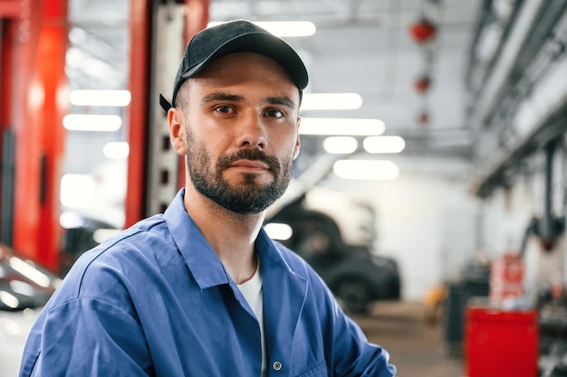 Retrato de um mecânico de automóveis que está na garagem Serviço de Reparação