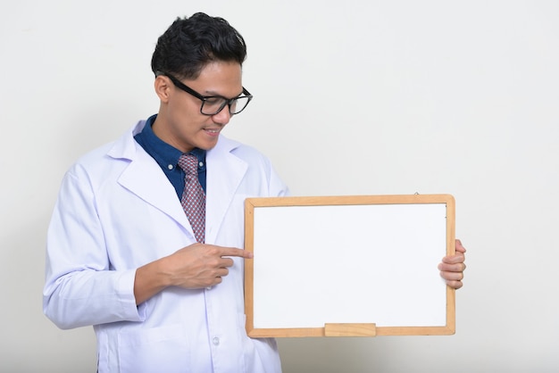 Retrato de um médico asiático segurando um quadro branco