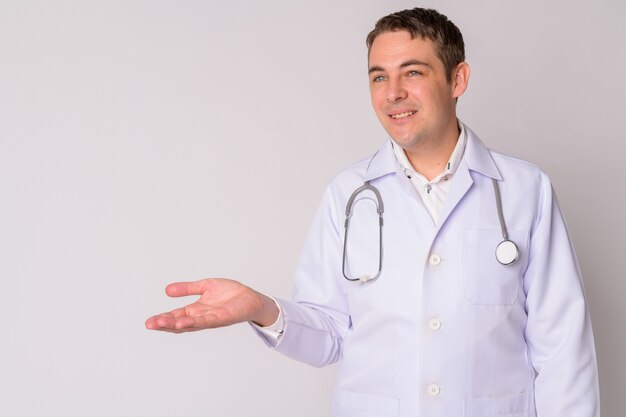 Retrato de um médico bonito contra uma parede branca