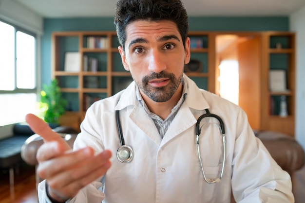 Retrato de um médico em uma videochamada para uma consulta virtual com um paciente. Novo estilo de vida normal. Conceito de cuidados de saúde e medicina.