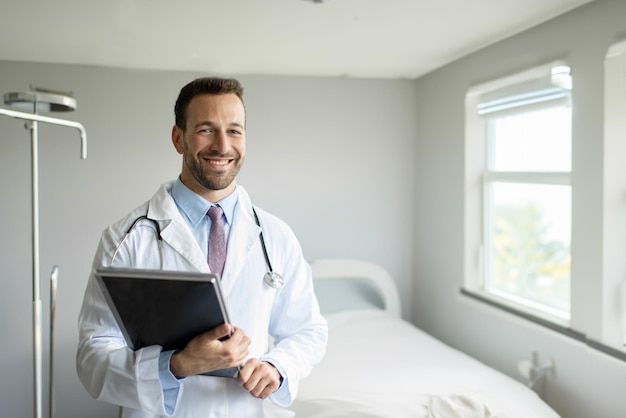 Foto retrato de um médico europeu amigável em roupas de trabalho com um estetoscópio ao redor de seu pescoço posando