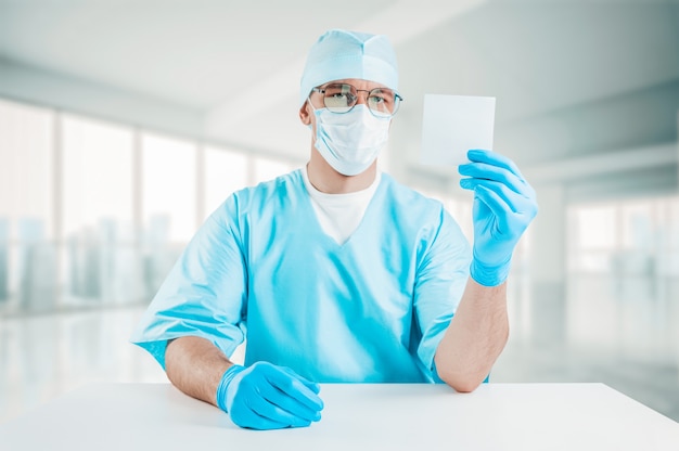 Retrato de um médico segurando uma folha de papel branca na mão