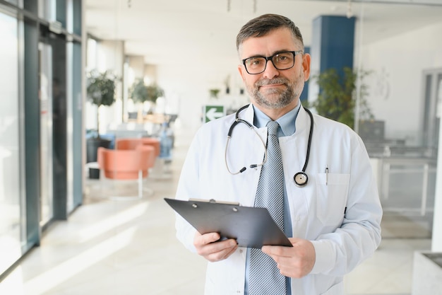 Foto retrato de um médico sênior em seu consultório em um hospital