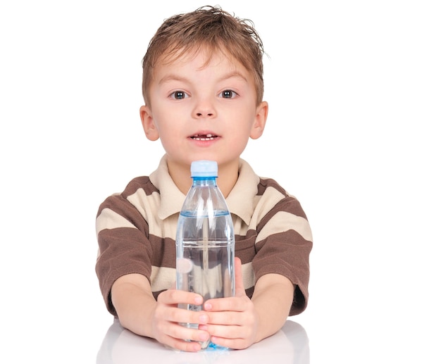 Retrato de um menino alegre com uma garrafa de plástico de água Criança sorridente com uma botella de água refrescante isolada em fundo branco