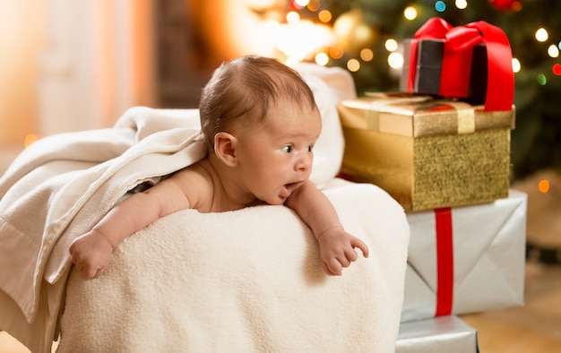 Retrato de um menino animado olhando para a pilha de presentes de Natal