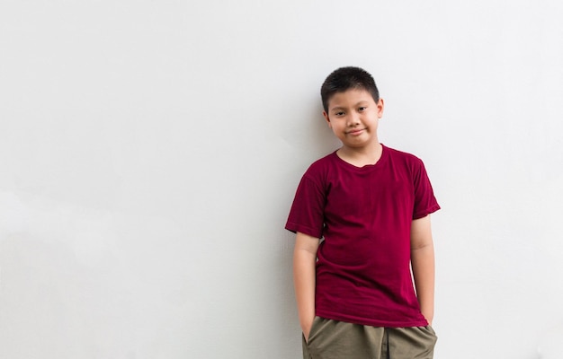 Retrato de um menino asiático bonito em pé sorrindo alegremente confiante