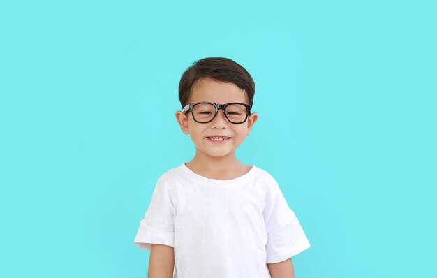 Retrato de um menino asiático sorridente usando óculos isolados sobre fundo ciano