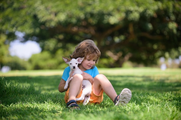 Retrato de um menino bonitinho com cachorro relaxando na natureza