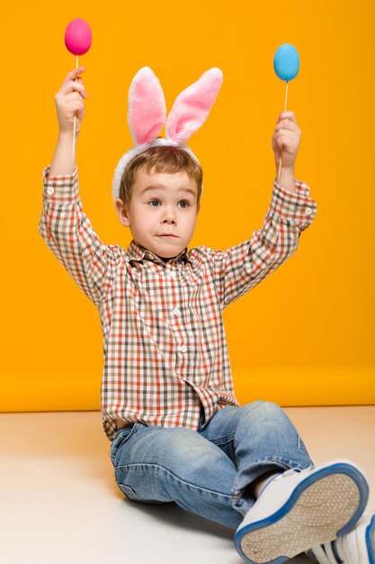 Foto retrato de um menino bonito brincando com brinquedos no chão de madeira