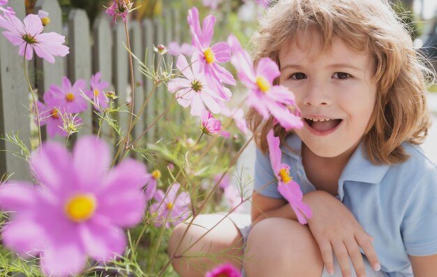 Retrato de um menino bonito com flores da primavera feche o rosto de crianças caucasianas closeup cabeça de criança engraçada