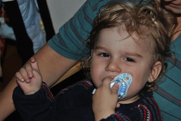 Foto retrato de um menino bonito com o pai segurando uma chupeta