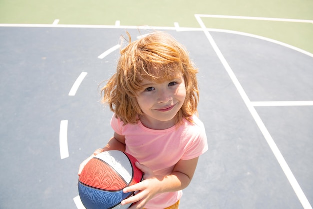 Foto retrato de um menino bonito criança jogar basquete. cara engraçada de crianças.