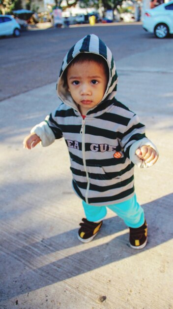 Foto retrato de um menino bonito de pé na rua