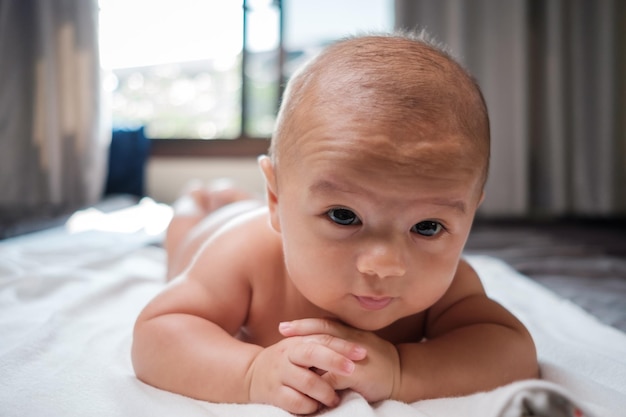 Retrato de um menino bonito deitado na cama em casa