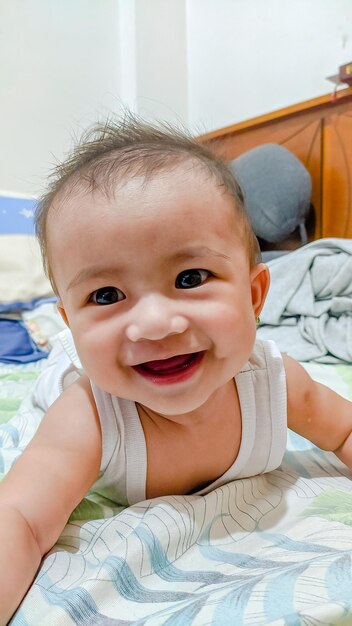 Foto retrato de um menino bonito deitado na cama em casa