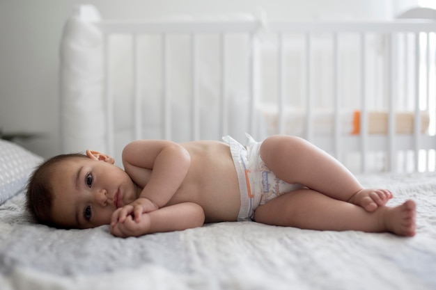 Retrato de um menino bonito deitado na cama em casa