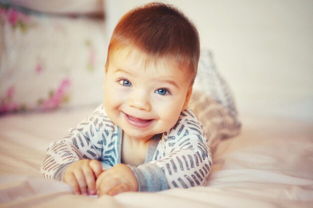 Retrato de um menino bonito deitado na cama