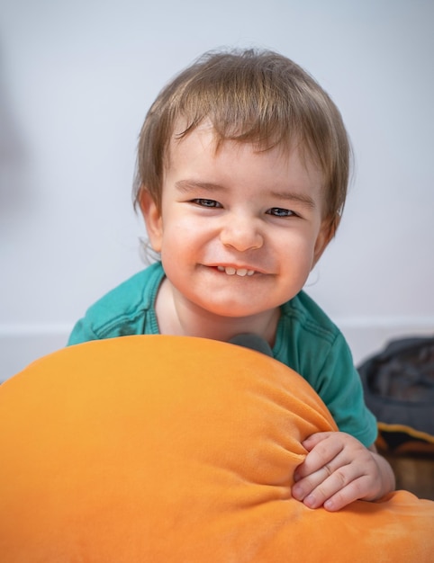 Foto retrato de um menino bonito e sorridente com um travesseiro