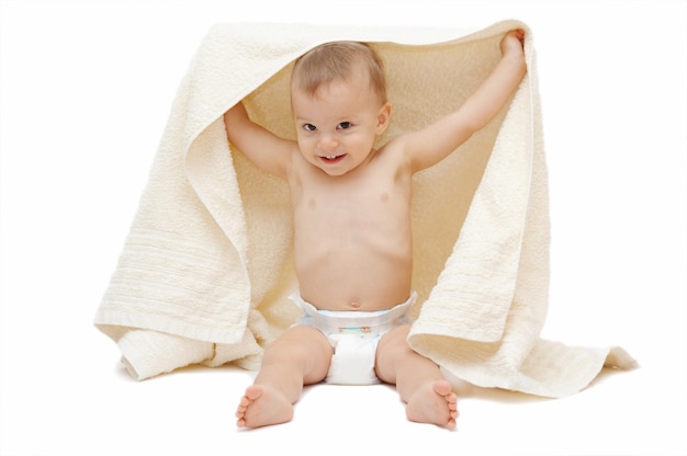 Foto retrato de um menino bonito segurando uma toalha enquanto está sentado contra um fundo branco
