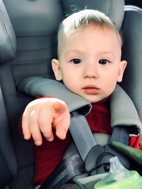 Retrato de um menino bonito sentado no carro