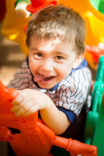 Retrato de um menino bonito sorridente brincando com brinquedo em casa