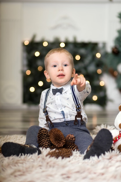 Retrato de um menino brincar com pinhas perto de uma árvore de Natal. Decorações de Natal. Feliz Natal e Feliz Ano Novo .