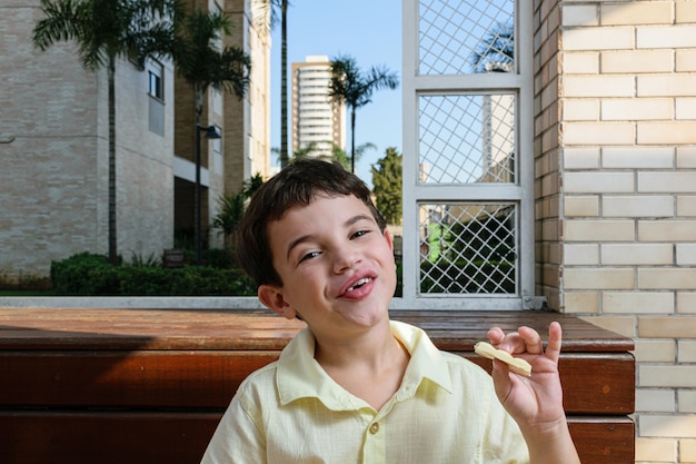 Retrato de um menino com uma barra de chocolate