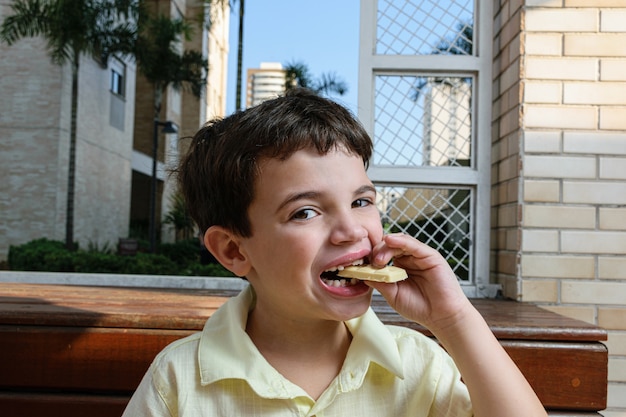 Retrato de um menino com uma barra de chocolate