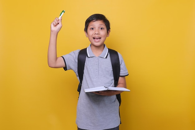 Retrato de um menino de escola asiático com uma expressão quando ele tem uma ideia ou solução usando po cinza