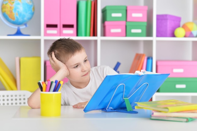 Retrato de um menino de óculos e livros fazendo aulas