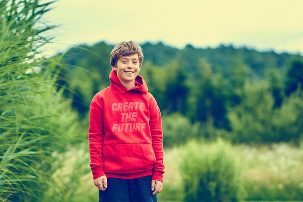 Retrato de um menino de pé no campo