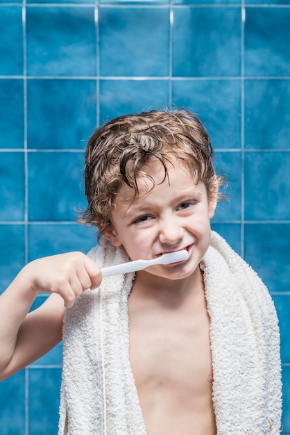 Retrato de um menino escovando os dentes