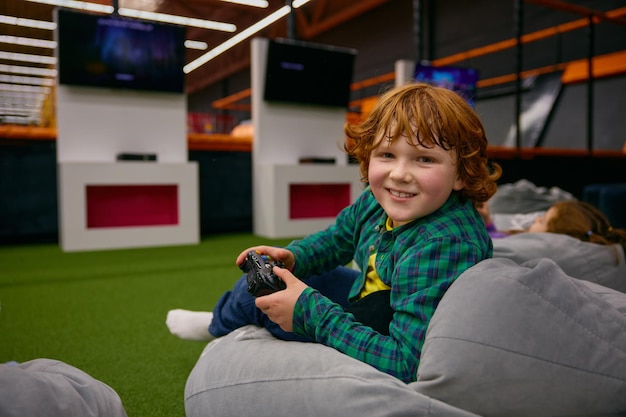Retrato de um menino feliz jogando videogame no centro infantil