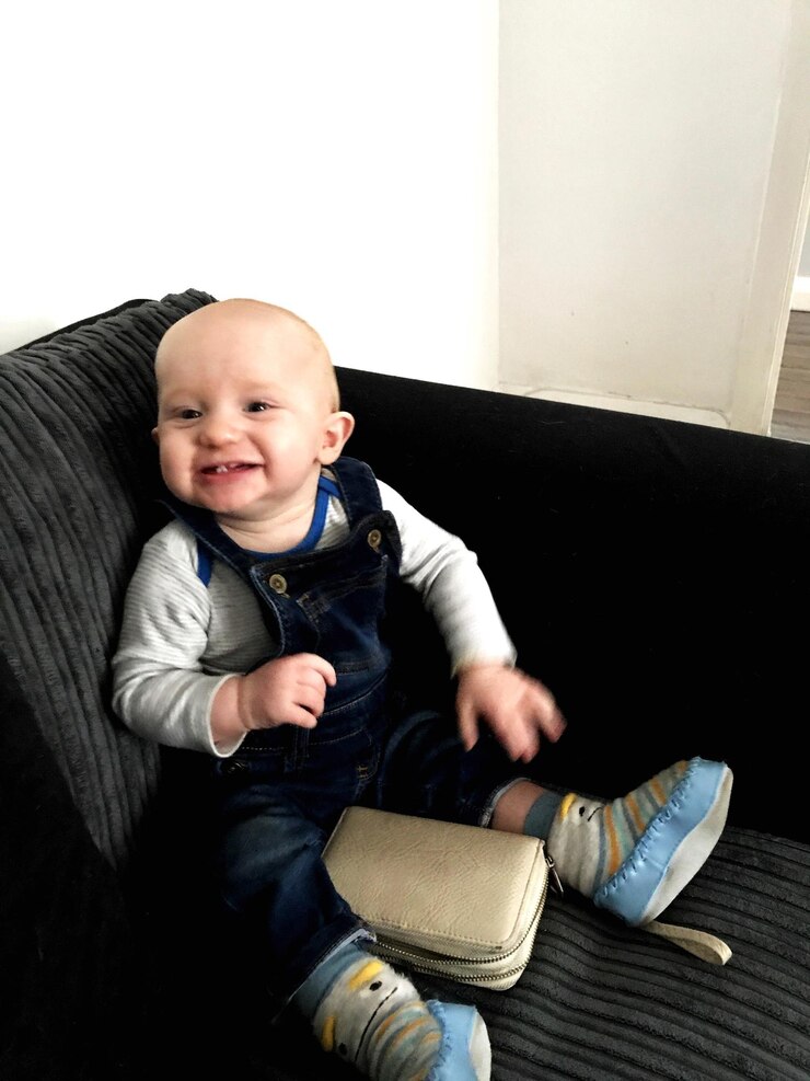 Foto retrato de um menino feliz sentado no sofá em casa