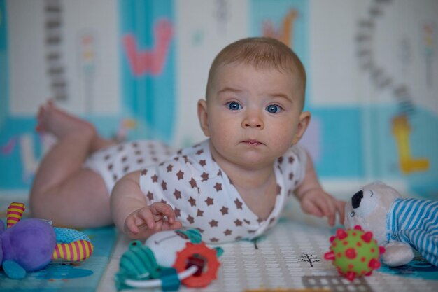 Retrato de um menino fofo deitado no chão com brinquedos