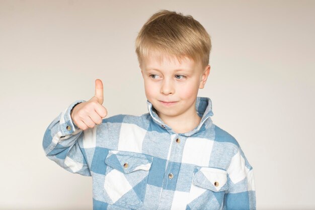 Foto retrato de um menino mostrando os polegares para cima