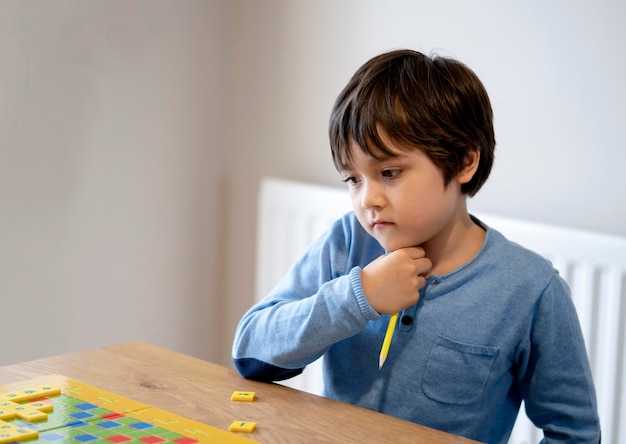 Foto retrato de um menino segurando uma mesa