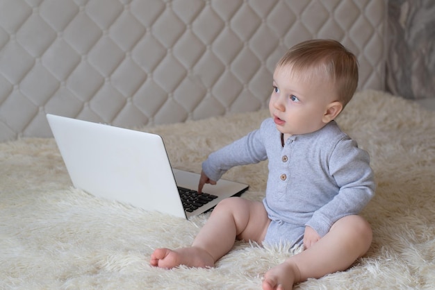 Foto retrato de um menino sentado com um laptop, um lugar para copiar