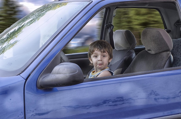 Retrato de um menino sentado em um carro