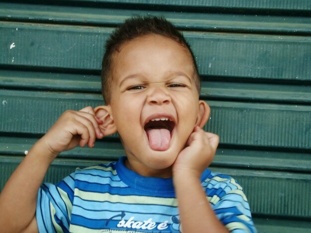 Foto retrato de um menino sentado perto de um obturador