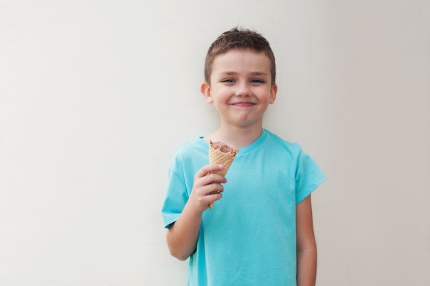 Retrato de um menino sorridente de pé contra um fundo branco