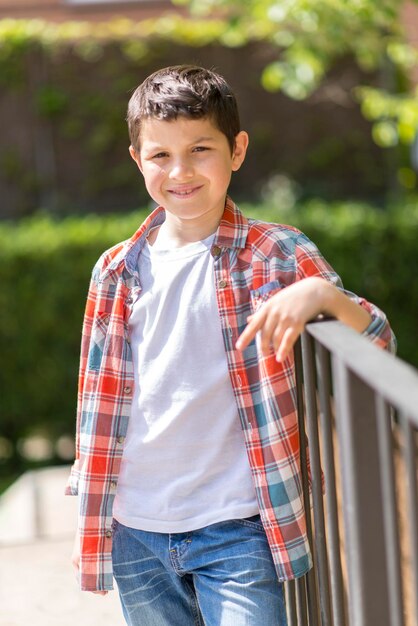 Foto retrato de um menino sorridente de pé junto ao corrimão