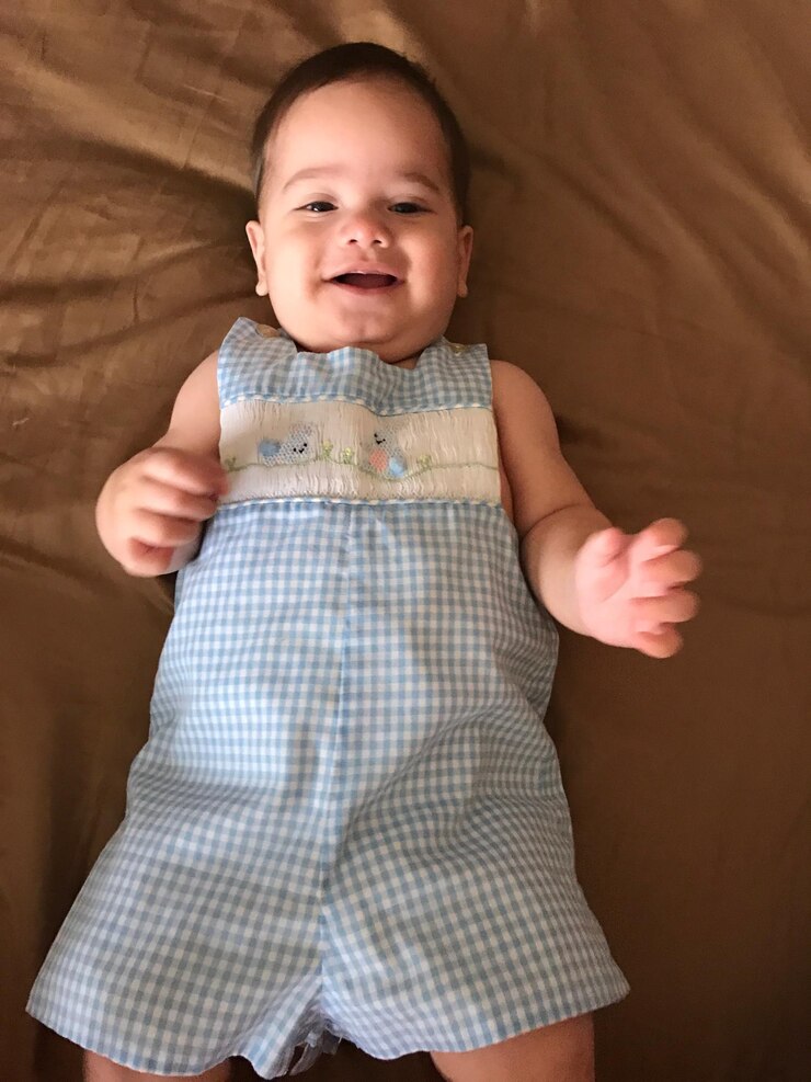 Foto retrato de um menino sorridente deitado na cama