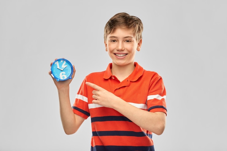 Foto retrato de um menino sorridente feliz com um despertador