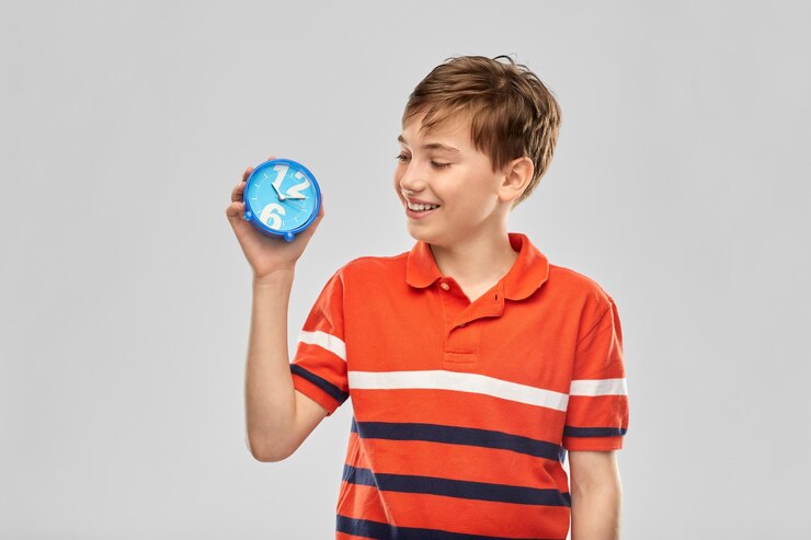 Foto retrato de um menino sorridente feliz com um despertador