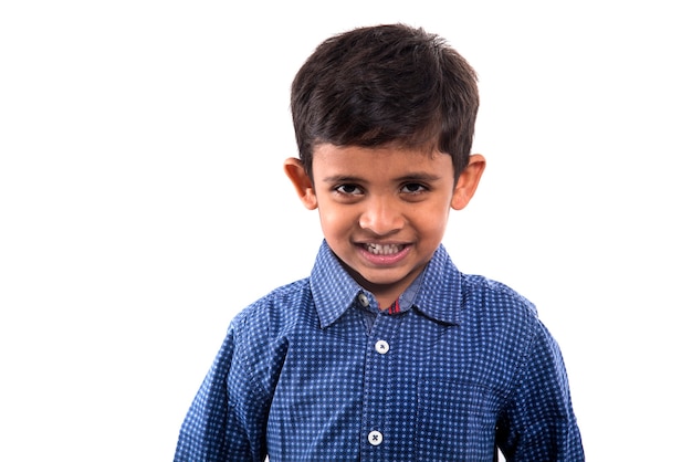 Retrato de um menino sorridente, posando em uma parede branca.